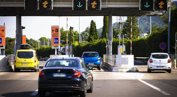Voitures attendant au péage de l'autoroute A49. Panneaux lumineux indiquant les voies.