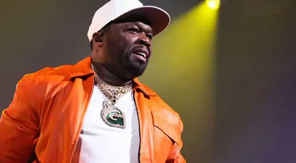 50 Cent w pomarańczowej kurtce i białej czapce, z błyszczącym naszyjnikiem. Bilety na jego koncert rozchodzą się jak ciepłe bułeczki.