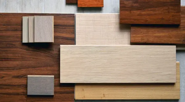 Campione di diversi tipi di parquet in varie tonalità di legno, dal chiaro al scuro, con venature visibili.