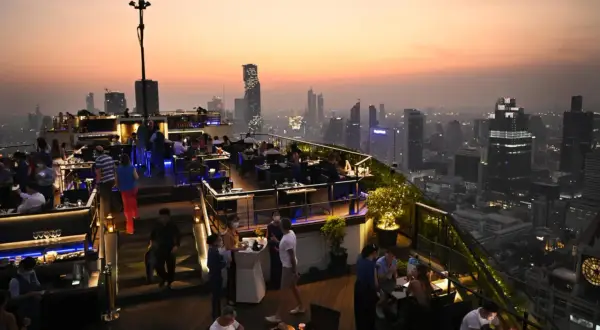 Abendstimmung auf einer Dachterrasse in Bangkok. Ein perfekter Ort, um die Skyline bei einem Drink zu genießen, ideal für einen Kurztrip nach Bangkok in 2 Tagen.