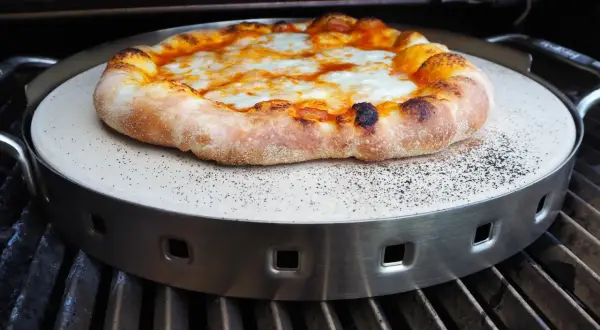 Pyszna pizza z grilla gazowego, z rumianym ciastem i ciągnącym się serem, pieczona na kamieniu.