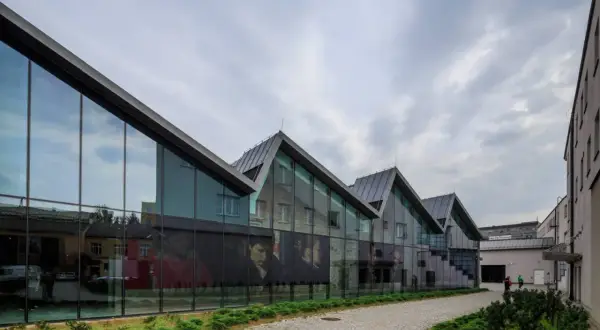 Nowoczesna architektura muzeum sztuki współczesnej w Krakowie Mocak z wielkoformatowymi portretami na szkle.