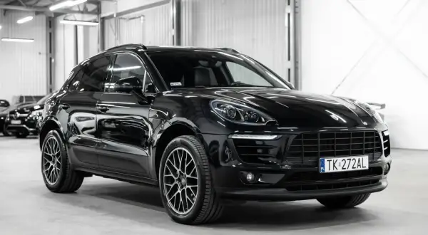 Czarny Porsche Macan lśni w garażu. Sprawdź atrakcyjną porsche macan cena i znajdź swój wymarzony SUV.