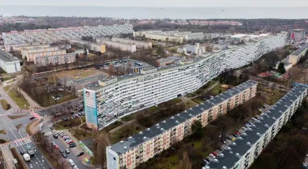 Długi, falisty blok mieszkalny i inne budynki w osiedlu. Kiedy najem prywatny staje się działalnością gospodarczą, takie widoki mogą przypominać o skali inwestycji.