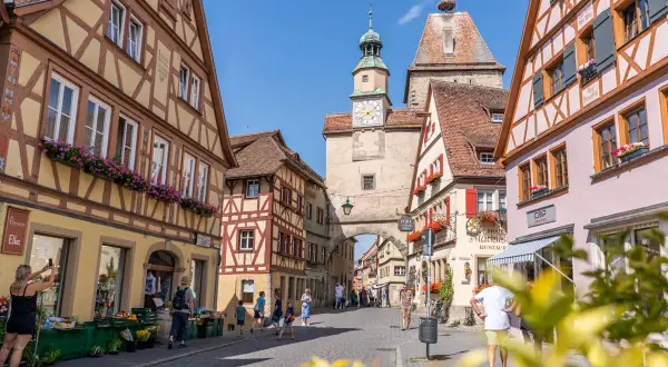 Entdecke die charmanten Gassen von Rothenburg ob der Tauber. Geheimtipps für deinen Besuch: Fachwerkhäuser, ein Marktplatz mit Uhrturm und blumengeschmückte Fenster.
