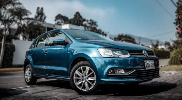 Niebieski samochód Volkswagen Polo zaparkowany na zewnątrz.