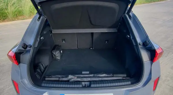 Bagagliaio aperto della Cupra Terramar, con ombrello e kit di emergenza. Le dimensioni sono adatte per un viaggio.