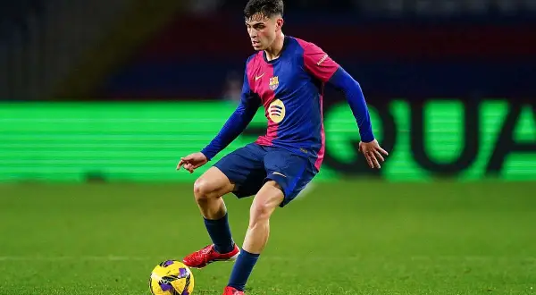 Pedro González, młody piłkarz FC Barcelony, drybluje z piłką na zielonej murawie.