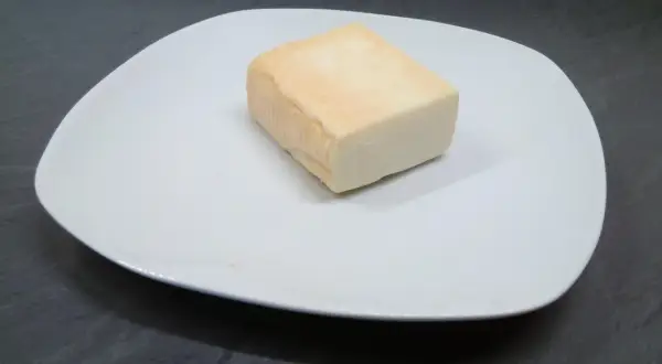 Kawałek sera taleggio na białym talerzu. Czy taleggio to dobry wybór na przekąskę?