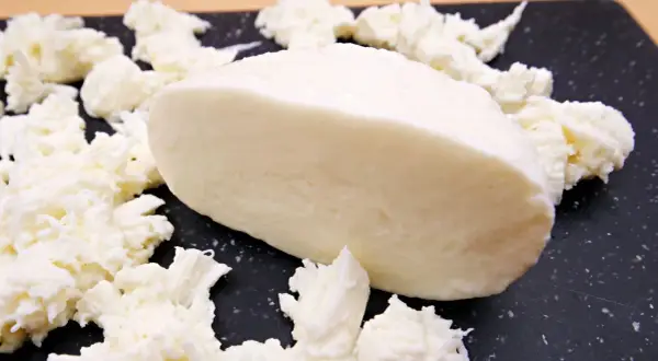 Kawałek świeżej mozzarelli, otoczony postrzępionymi kawałkami sera. Idealny do sałatek, a jego mozzarella kcal sprawia, że jest zdrowym wyborem.