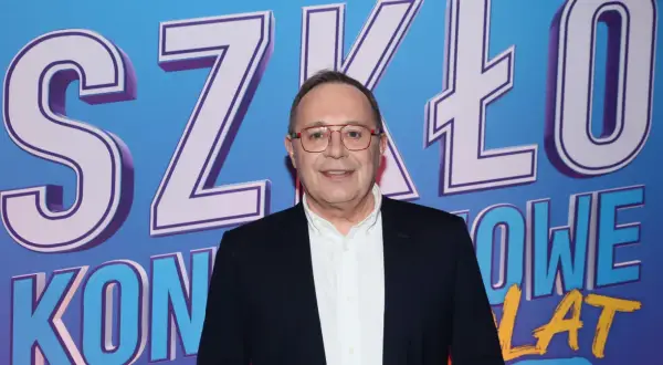 Uśmiechnięty mężczyzna w okularach na tle napisu "SZKŁO KONTAKTOWE OBSADA".