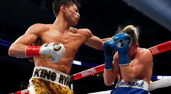 Boxer lands a powerful left hook, sending a spray of sweat and water into the air. This is how to throw a left hook with maximum impact.