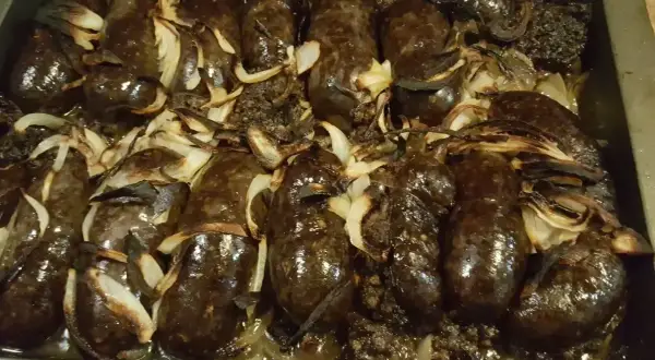 Kaszanka z grilla z cebulą w folii aluminiowej, pieczona do perfekcji. Aromatyczna i soczysta, gotowa do podania.