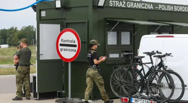 Strażnicy graniczni prowadzą kontrole graniczne Niemcy. Na posterunku stoi zielony kontener, obok niego funkcjonariusze i rowerzyści.