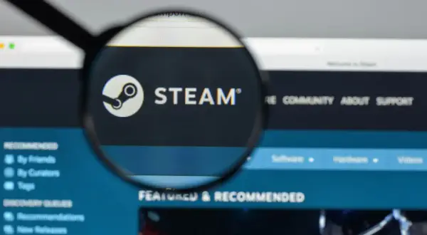 Lupa powiększająca logo Steam i napis "STEAM" na ekranie komputera.