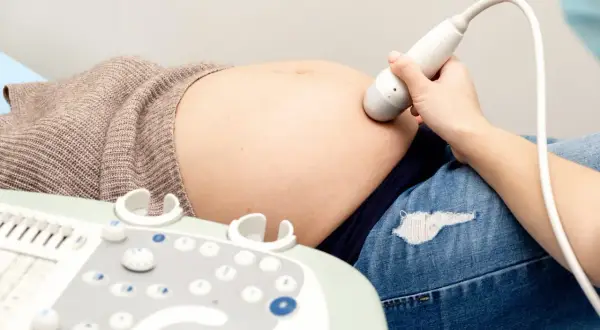 Badanie USG brzucha ciężarnej, sonda przykładana do skóry. Wyniki mogą posłużyć do stworzenia tabeli tętna płodu.