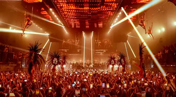 Folla festante con smartphone alzati per catturare lo spettacolo aereo e le performance, un'anticipazione dell'apertura discoteche Ibiza.