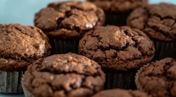 Kilka czekoladowych muffinek w papierowych papilotkach, zbliżenie.