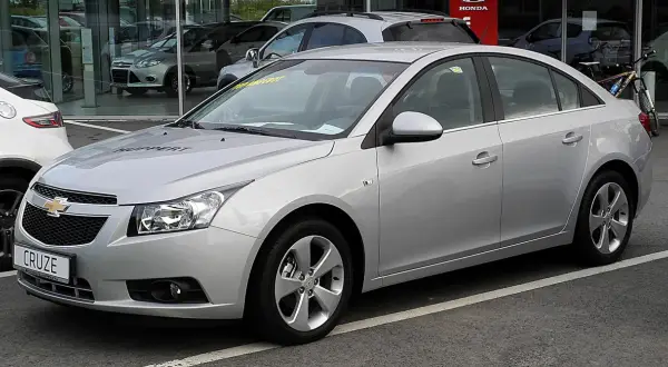Srebrny Chevrolet Cruze na parkingu. Wiele osób szuka chevrolet cruze opinie przed zakupem.