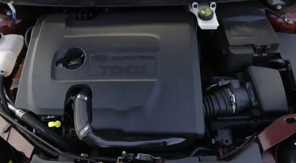 Silnik Ford Focus MK2 1.6 TDCI. Widoczna czarna osłona silnika z napisem "DURATORQ TDCI".