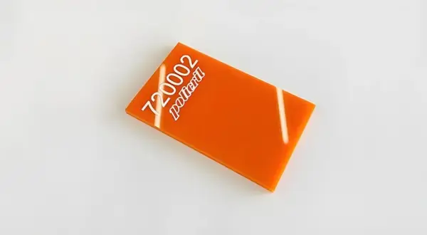 Un échantillon de plexi orange vif, portant le numéro 720002 et le mot "policril" en blanc.