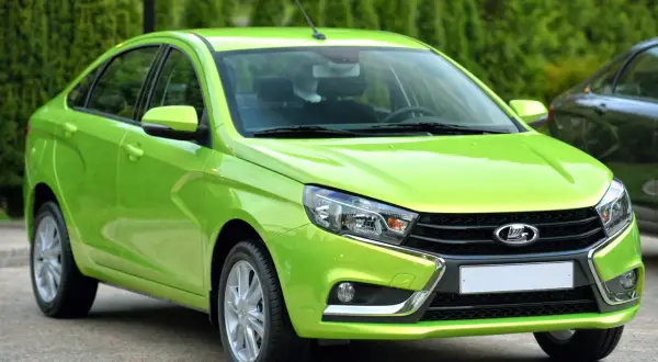 En ljusgrön Lada Vesta står parkerad utomhus.
