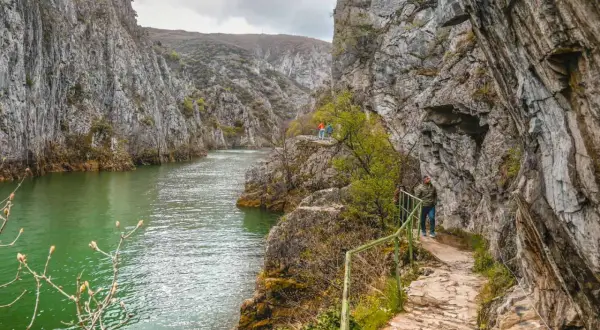 Vandra längs stigen i Matka Canyon, med turkost vatten och dramatiska klippor.