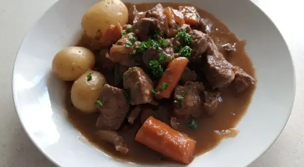 En härlig fransyska gryta med möra köttbitar, mjuka potatisar och saftiga morötter, toppad med färsk persilja.