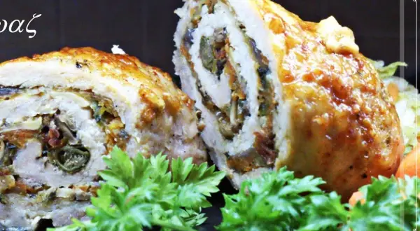 Roladki schabowe pieczone w naczyniu, z widocznym nadzieniem z warzyw i suszonych pomidorów, ozdobione natką pietruszki.