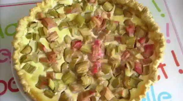 Tarte à la rhubarbe sur pâte feuilletée, garnie de morceaux de rhubarbe et d'une crème onctueuse. Un délice printanier !