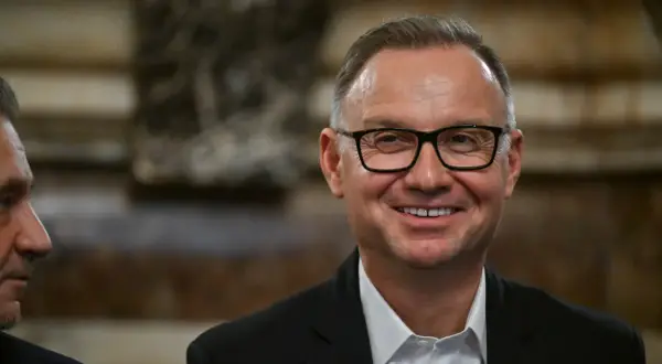 Uśmiechnięty mężczyzna w okularach, w garniturze. Czyżby planował już emeryturę prezydencką?