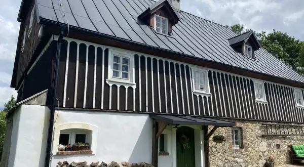 Jak sprawdzić czy budynek to zabytek? Ten dom z kamienia i drewna, z charakterystycznym dachem i oknami, może być cennym obiektem historycznym.