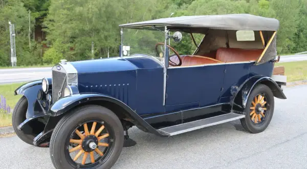 En mörkblå Volvo Car AB cabriolet från tidigt 1900-tal med bruna lädersäten och träekerhjul.