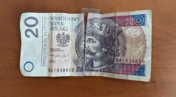 Rozdarty banknot 20 zł, sklejony taśmą. Czy można skleić banknoty? Tak, ale czy bank będzie je przyjmował?