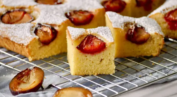 Saftiger Zwetschgenkuchen vom Blech, mit Puderzucker bestäubt und saftigen Zwetschgen belegt. Ein Genuss für jede Kaffeetafel.
