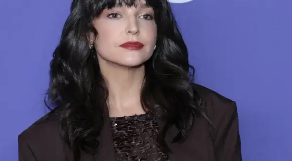 Maria Dębska, z partnerem u boku, prezentuje się elegancko w ciemnej marynarce i błyszczącej bluzce.