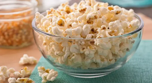 Chrupiąca góra popcornu w szklanej misce. Czy popcorn jest zdrowy? Zależy od dodatków!