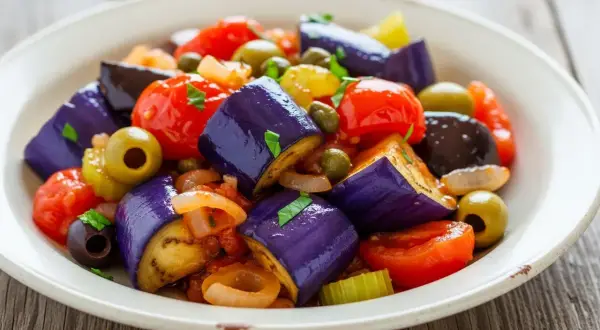 En härlig caponata med aubergine, tomater, oliver och kapris. Ett perfekt recept för en smakrik sallad.