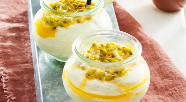 Zwei Gläser mit cremigem Dessert und Passionsfrucht-Topping.