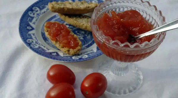 Tomatmarmelad i en skål, serverad på knäckebröd. Ett enkelt tomatmarmelad recept att prova.