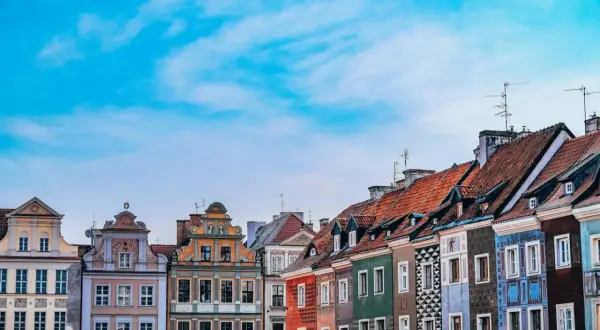 Kolorowe kamienice na Starym Rynku w Poznaniu, województwo wielkopolskie, pod błękitnym niebem.