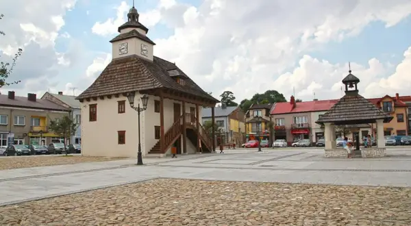 Rynek w Pilicy z ratuszem i studnią. Urokliwe miasto z brukowanym placem i kolorowymi kamienicami.