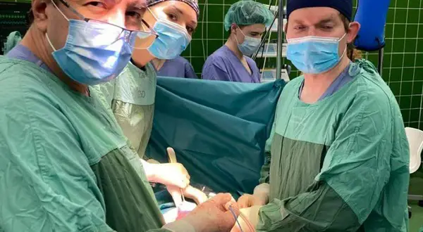 Chirurdzy w maseczkach i fartuchach podczas operacji. Jak podziękować chirurgowi za operację? Warto docenić ich pracę.
