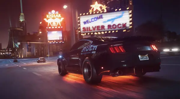 Czarny Ford Mustang z napisem "STUCK FOUNDATIONS" pędzi nocą przez miasto, zostawiając za sobą ogniste ślady. Czy Twój sprzęt sprosta wymaganiom NFS Payback?