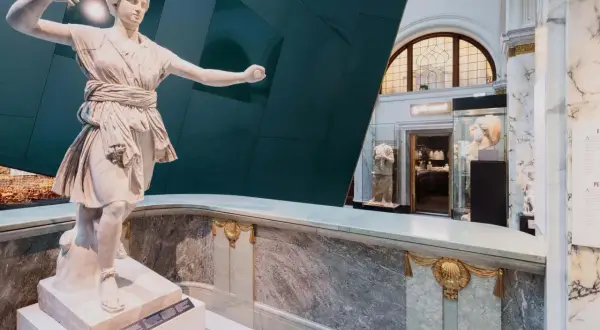 Antik staty i ett bra museum i Stockholm. Marmor och en grön vägg skapar en dramatisk bakgrund.