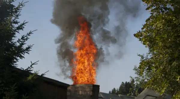 Flammen schlagen aus einem Schornstein, dunkler Rauch steigt auf. Ob man Europaletten verbrennen darf, ist fraglich.
