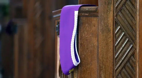 Fioletowa stuła w konfesjonale, symbol pokuty i pojednania. Grzechy po których nie można przystąpić do komunii wymagają spowiedzi.