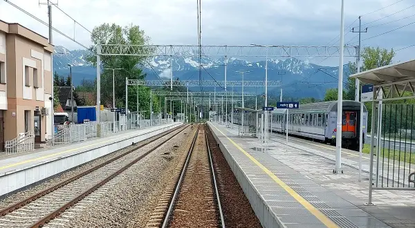 Stacja kolejowa z widokiem na góry. Pociąg gotowy do podróży na trasie Zakopane - Kraków. Czas przejazdu zależy od wybranego połączenia.