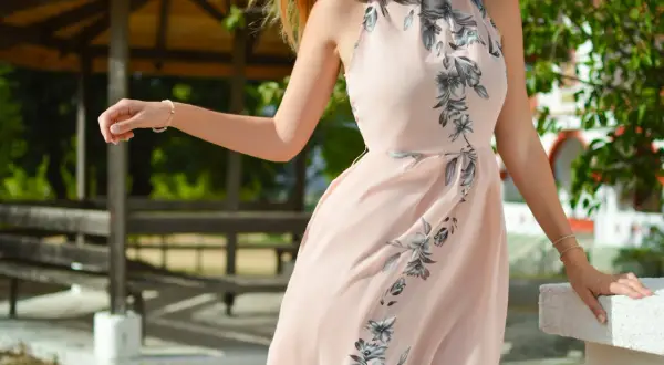 Elegancka sukienka w kwiaty, idealna moda dla 40 latki. Delikatny róż i subtelny wzór podkreślają kobiecość.