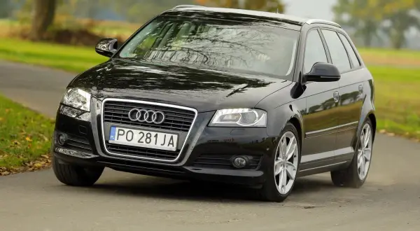 Czarne Audi A3 1.6 benzyna na drodze. Wiele osób chwali ten model za niezawodność i komfort jazdy.